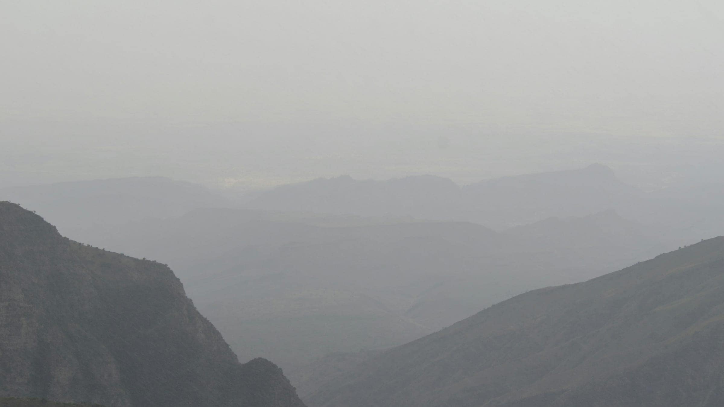 Camadas de montanhas se dissolvendo na bruma, até o horizonte.